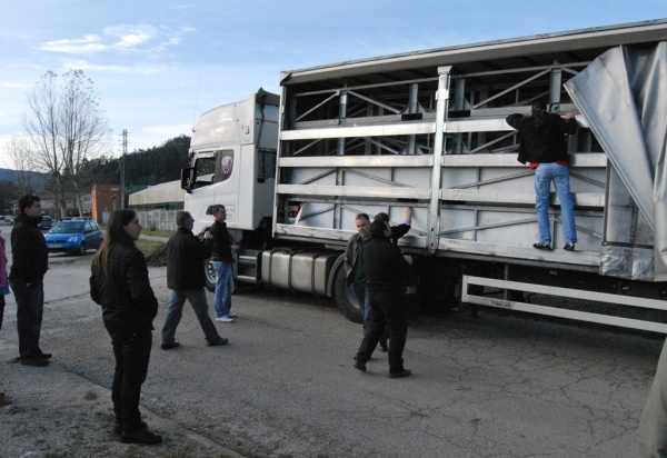 Los trabajadores revisan la carga de los camiones