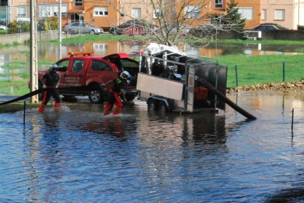 Bomberos achicando el agua que entraba en la finca Santa María