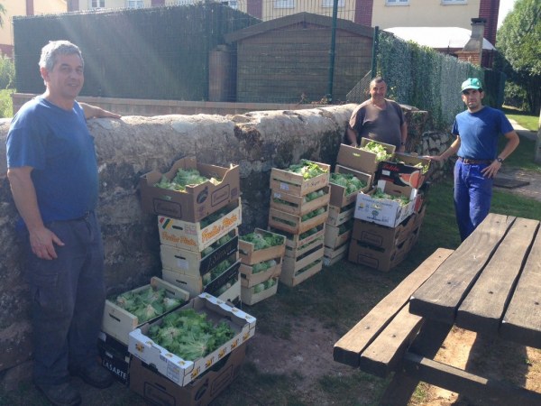 Trabajadores del huerto junto a productos recogidos.
