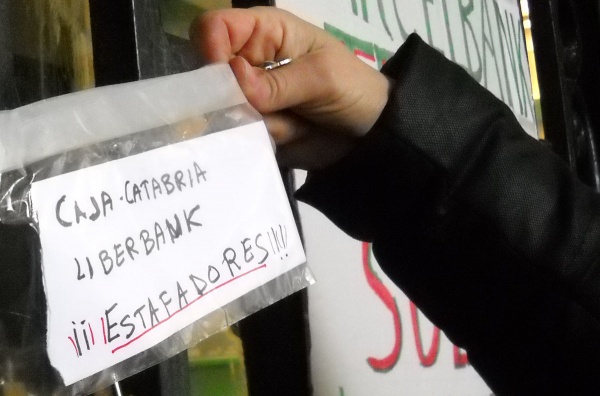 Uno de los carteles colocados ayer en la sede central de Caja Cantabria