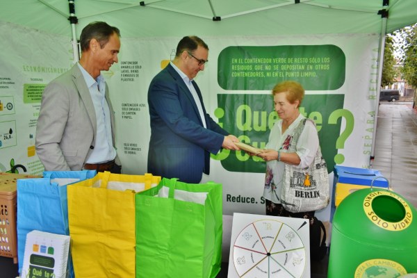Javier Conde junto a Alberto Quijano entregando una mochila a Carmen Gómez, ganadora del concurso en Valle de Buelna FM