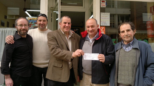 El acertante, a la izquierda, recibe el talón del presidente del Buelna