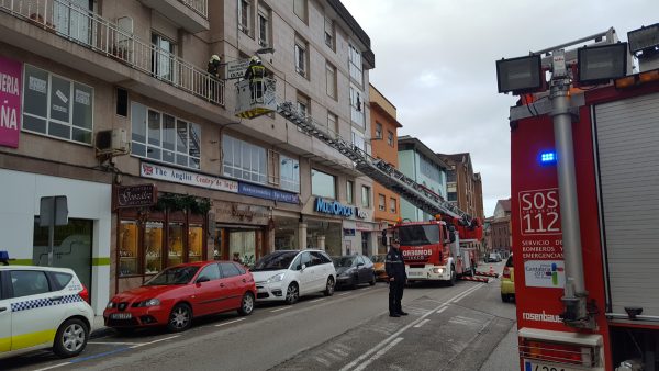 Bomberos retirando un cartel publicitario por peligro para los viandantes